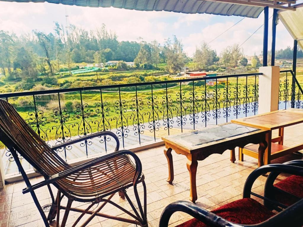 乌提SNR Cottage & Rooms的设有一个配有桌椅并享有美景的阳台。