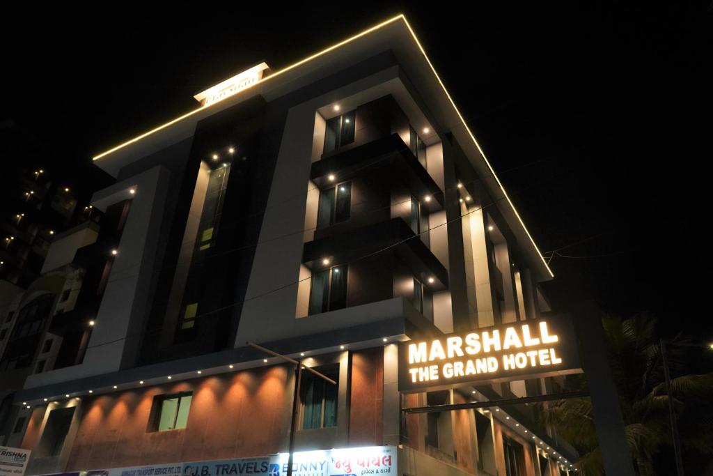 艾哈迈达巴德Marshall The Grand Hotel的一座建筑,在晚上前有标志