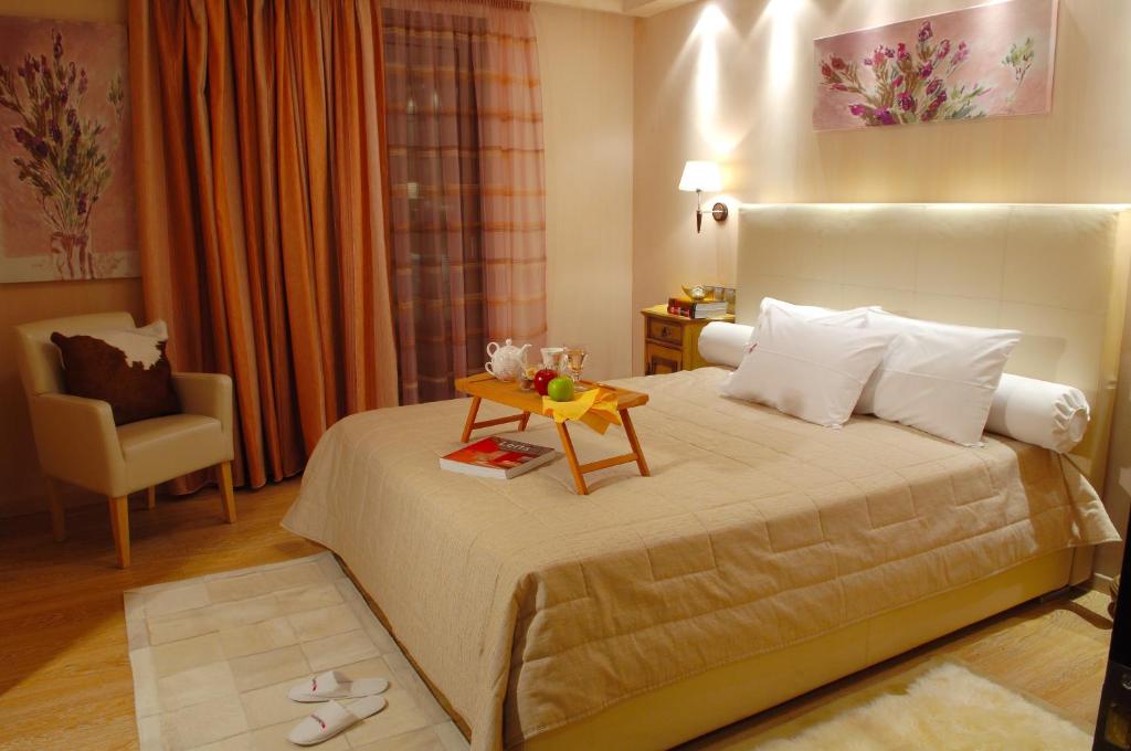 雅典Olympic Fashion Hotels的一间卧室配有一张带桌子和椅子的床