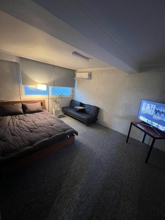 首尔Apartment in Gangnam的一间卧室配有一张床和一台平面电视