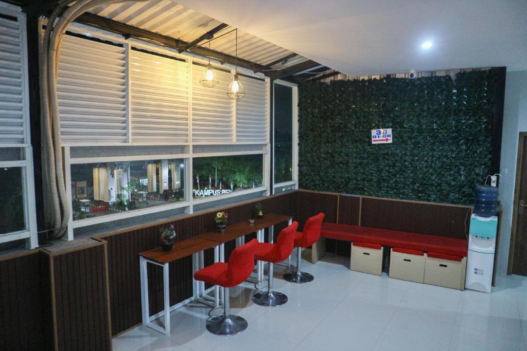 泗水K1 UPN的一间带红色椅子的餐厅和一间设有窗户的酒吧