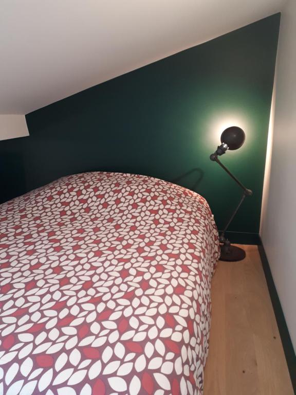 巴黎巴黎小舍公寓的一间卧室,卧室内配有一张床和一盏灯