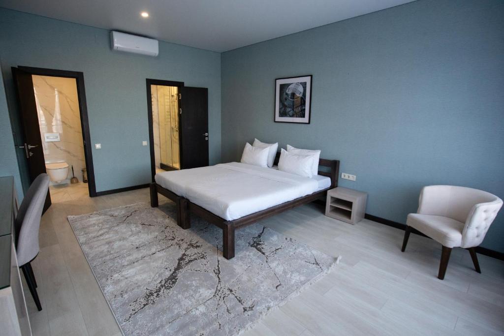 QaskelengArman Dala Resort的卧室配有白色的床和椅子
