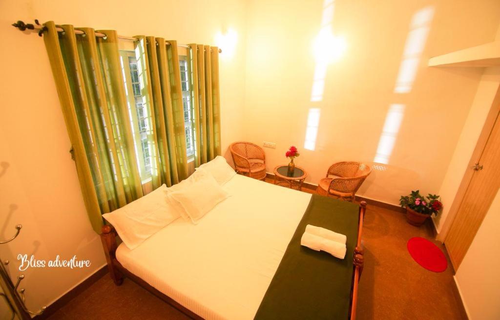 ViriparaBreeze Hill resort的小房间,配有一张床和两把椅子