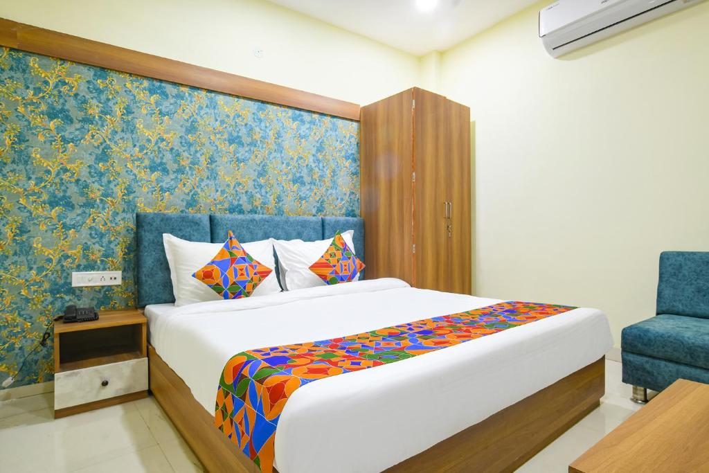 印多尔FabHotel Grand Giriraj的一间卧室配有一张床和一张蓝色椅子