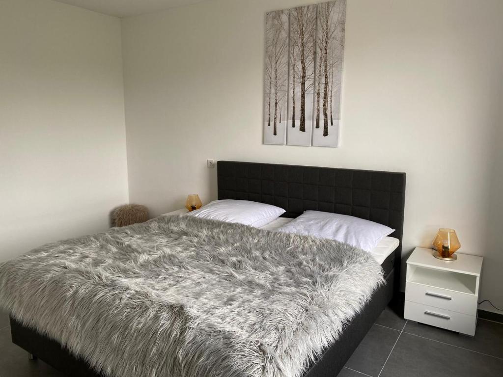 库克斯港Ferienwohnung PIER 1 in Cuxhaven的一间卧室配有一张带灰色毯子的床