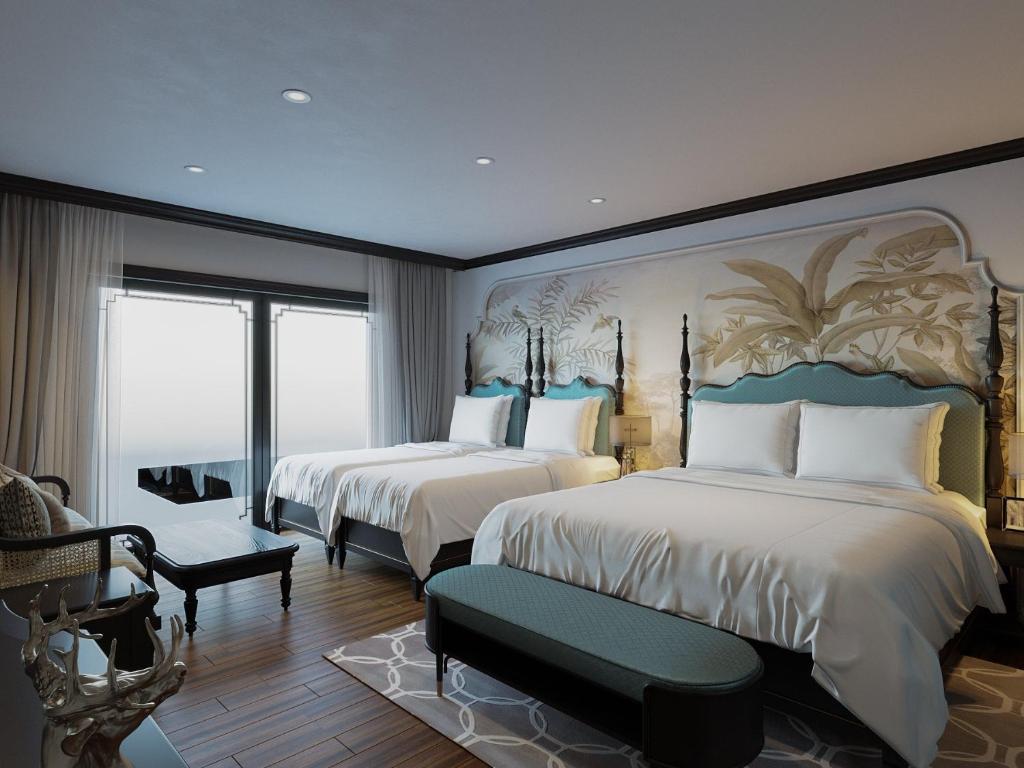 河内Aquarius Premium Hotel的酒店客房,配有两张床和椅子