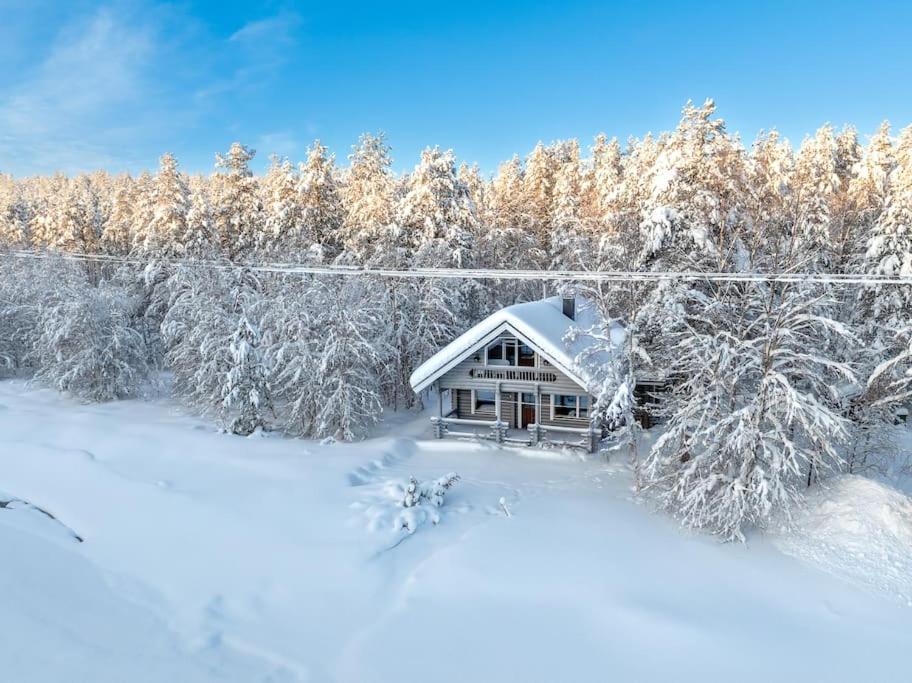 阿卡斯洛姆波罗Villa Äkäsjoensuu的雪中树下的房屋