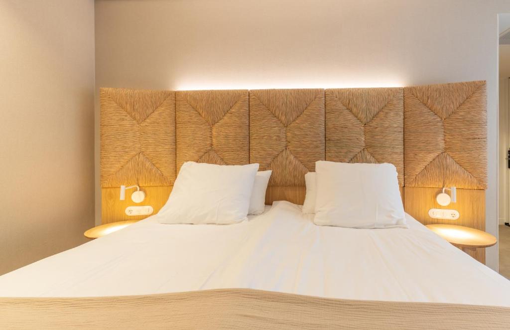 栋堡Strandhotel Domburg的一间卧室配有一张带两个白色枕头的大床