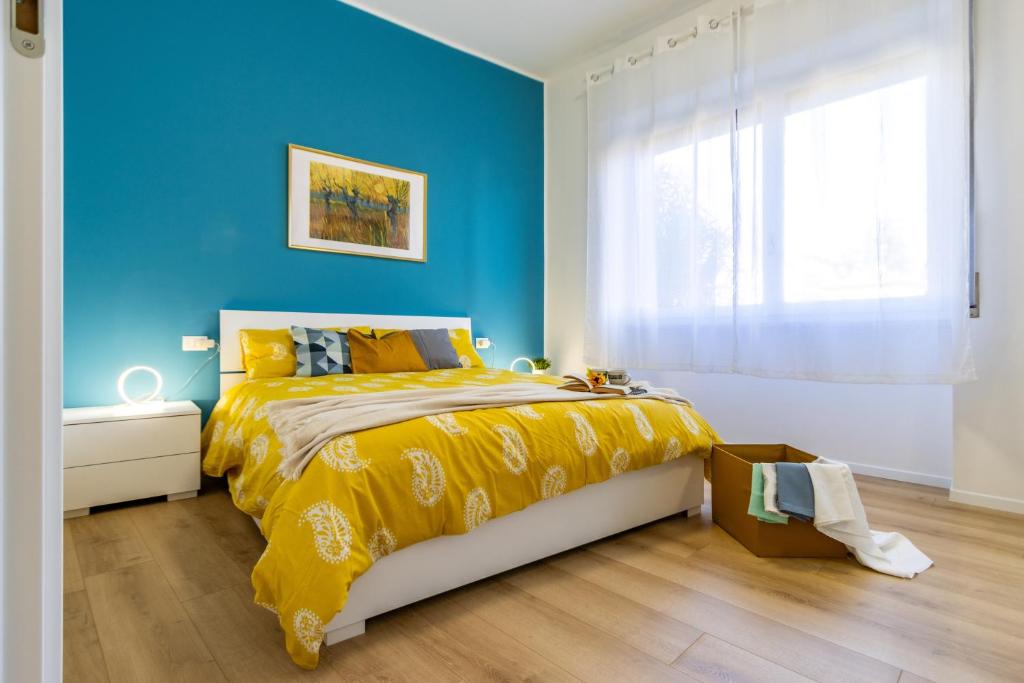 阿罗纳[Arona Centro] Blue Lake - Wi-Fi的蓝色卧室,配有一张带黄色床罩的床