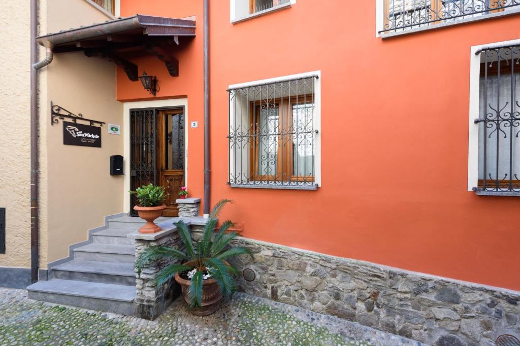 斯特雷萨Al San Michele的一座橙色的建筑,设有楼梯和门