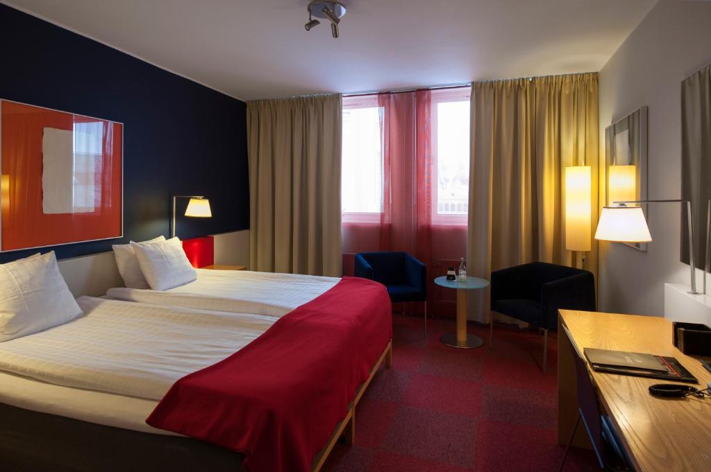 诺尔雪平ProfilHotels President的酒店客房设有一张大床和一张书桌。