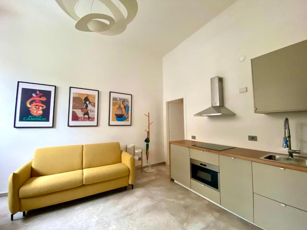 米兰La Cadrega的客厅设有黄色沙发,厨房设有