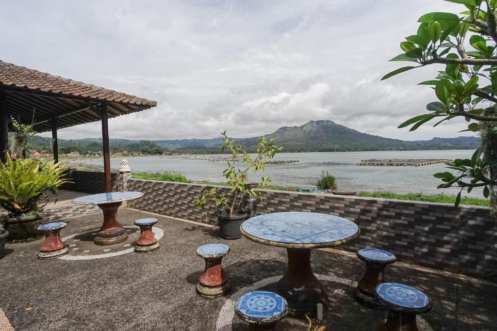 库布盼洛坎Baruna Lakeside View的一个带两张桌子的庭院,享有水景