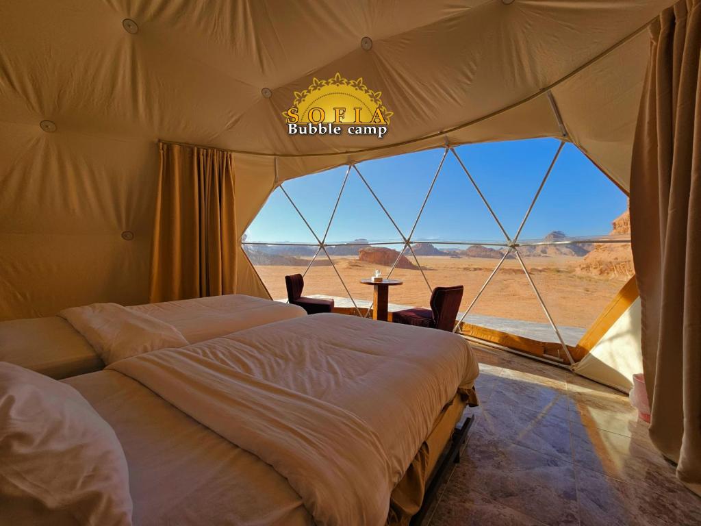 瓦迪拉姆Bubble Sofia Luxury Rum Camp的帐篷内的两张床,享有沙漠美景