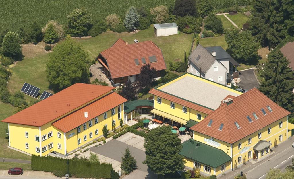 瓦格纳Hotel Restaurant Neuhold的享有红色屋顶的大型黄色房屋的顶部景色