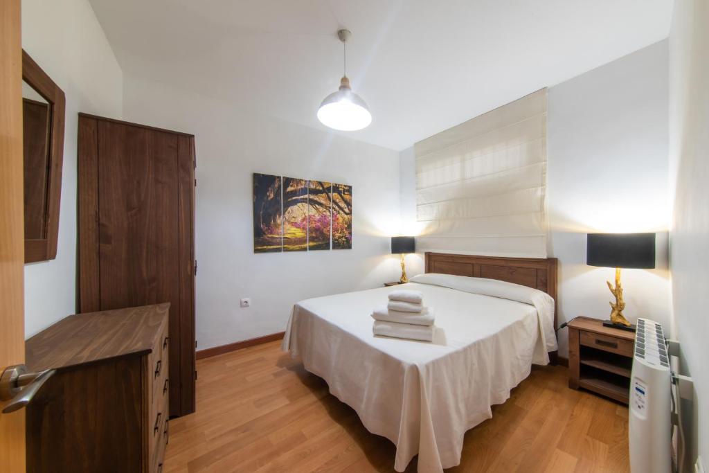圣玛丽亚港Apartamentos Moon Dreams Puerto的一间卧室配有一张床和一张桌子,上面配有毛巾