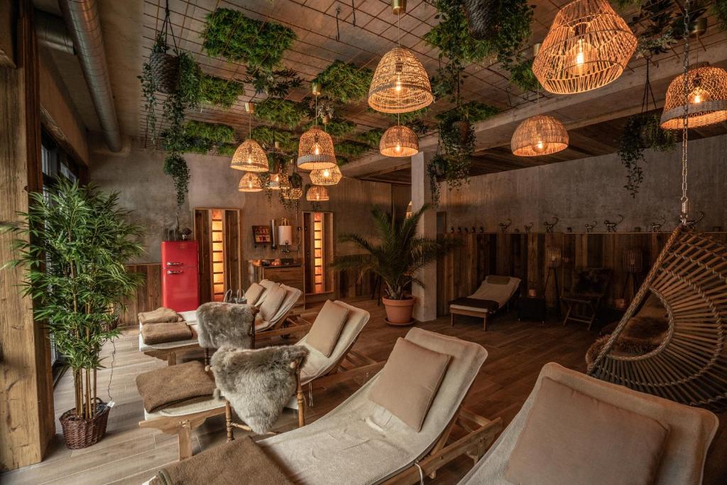 巴特莱辛哈尔Alpenstadthotels的大堂设有椅子、盆栽植物和吊灯