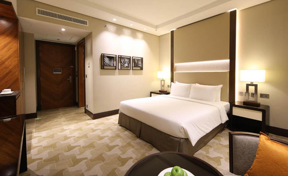 吉达Aerotel Jeddah的酒店客房设有一张大床和一张桌子。