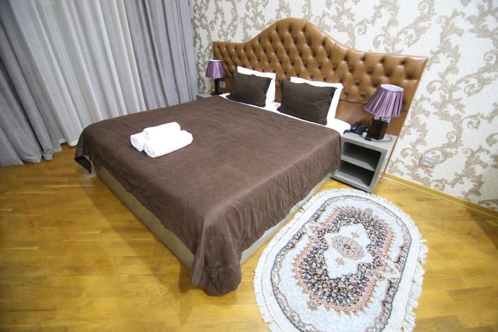 巴库Prime Hotel的一间卧室配有一张大床和大床头板