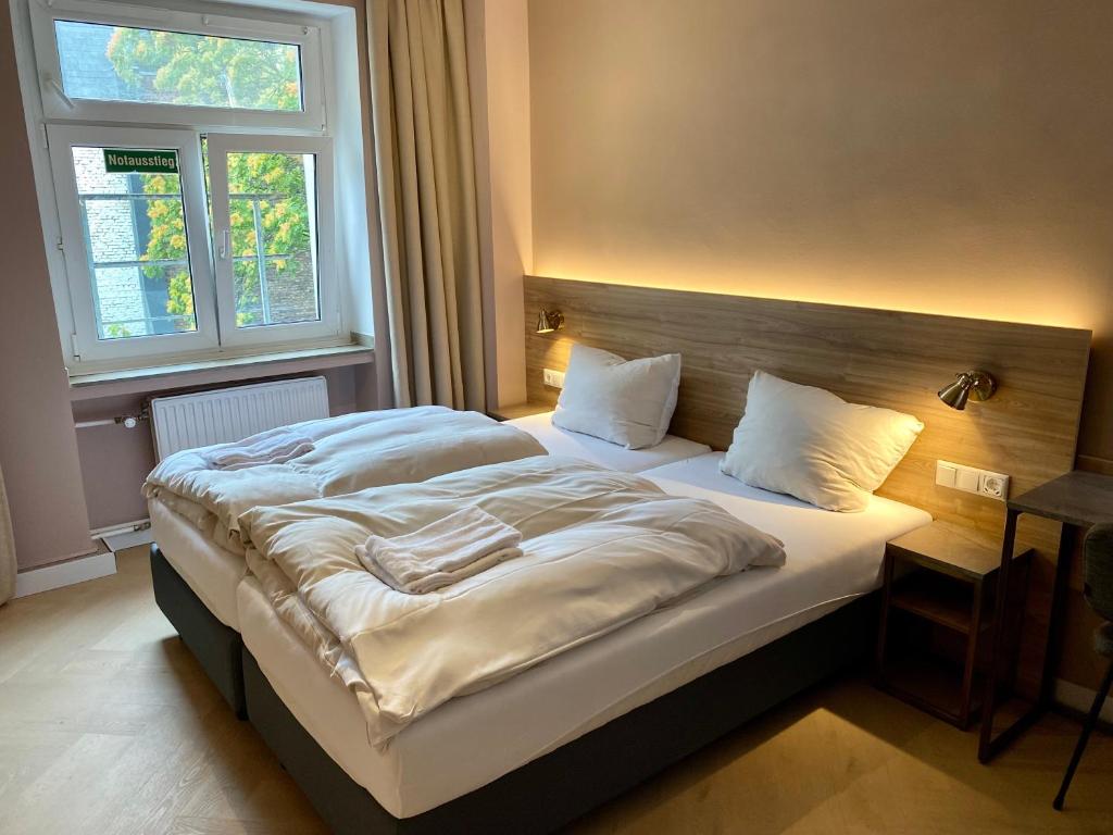 杜塞尔多夫Hotel Petite Königsallee SELF CHECK-IN的一间卧室配有一张大床和木制床头板