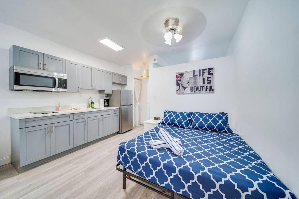 迈阿密海滩Beachy 1 b/r, w/2 Queen Beds, On Ocean Drive Beach的一间带蓝色床的卧室和一间厨房