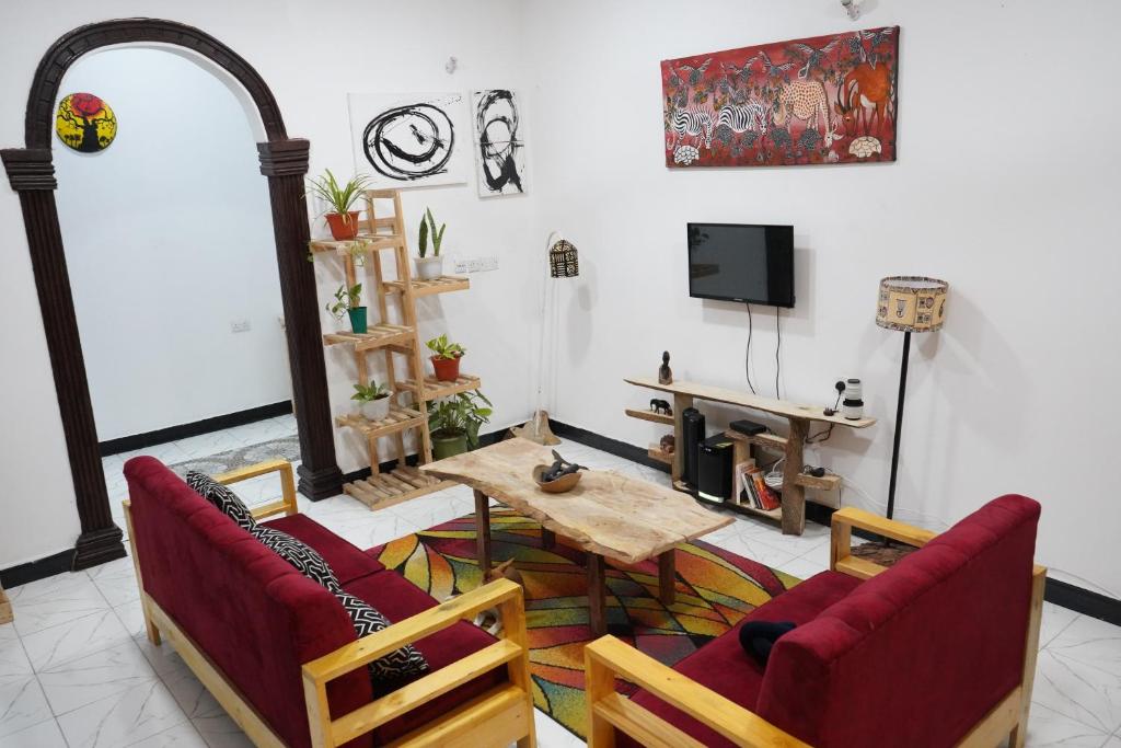 达累斯萨拉姆2 Bedroom spacious Cozy Home in Kigamboni,10 min Walk to Beach的客厅配有桌椅和电视。