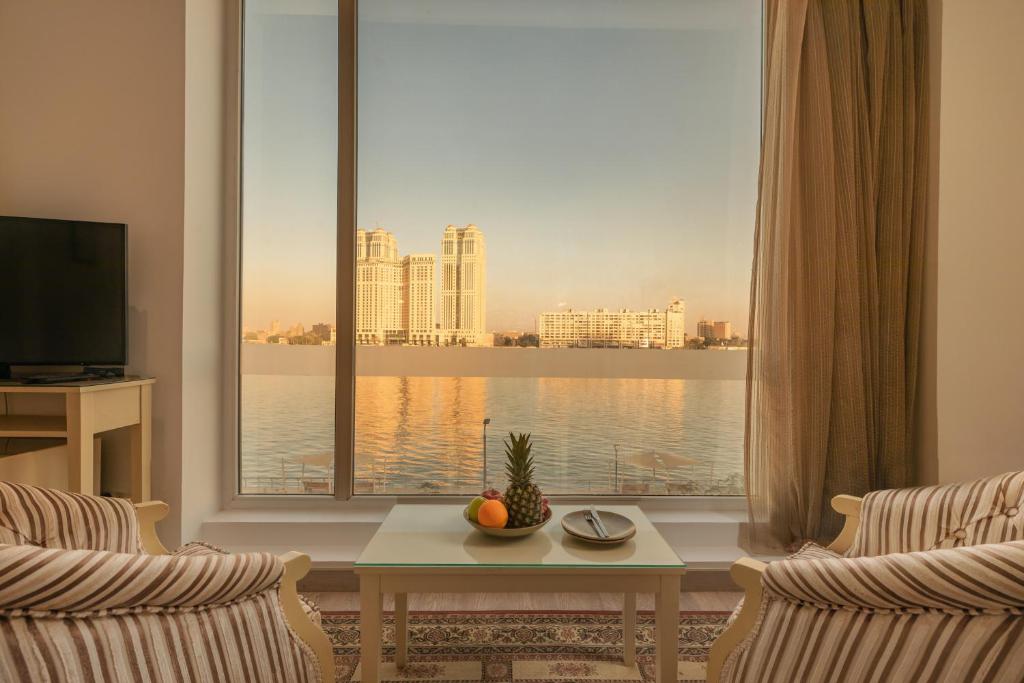 开罗Riverside Hotel的客厅设有大窗户,享有水景
