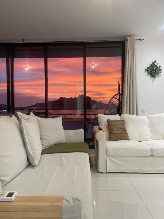 明德卢Ocean View Santa Filomena的带沙发和日落的客厅