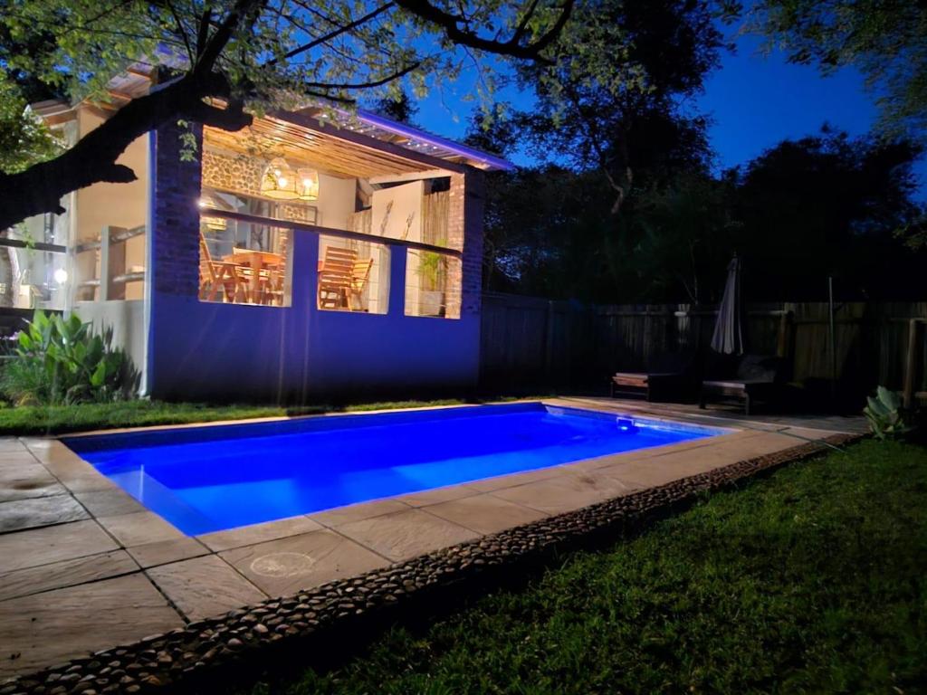侯斯普瑞特The Blyde Canyon House的房子前面的蓝色游泳池