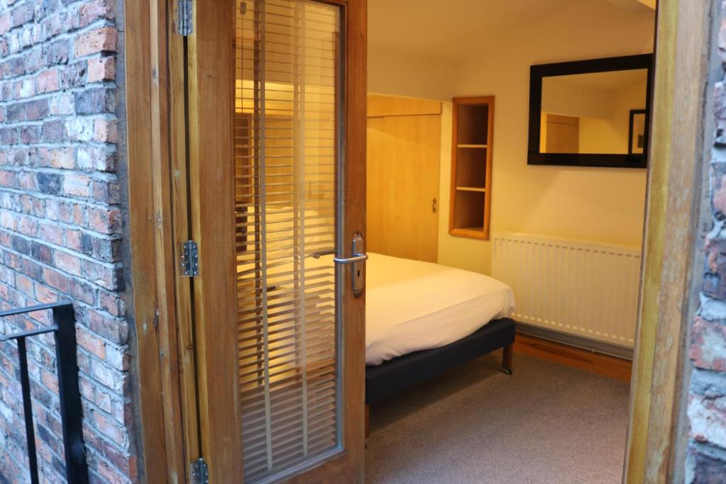 曼彻斯特Lower Turks Head的一间小卧室,配有床和砖墙