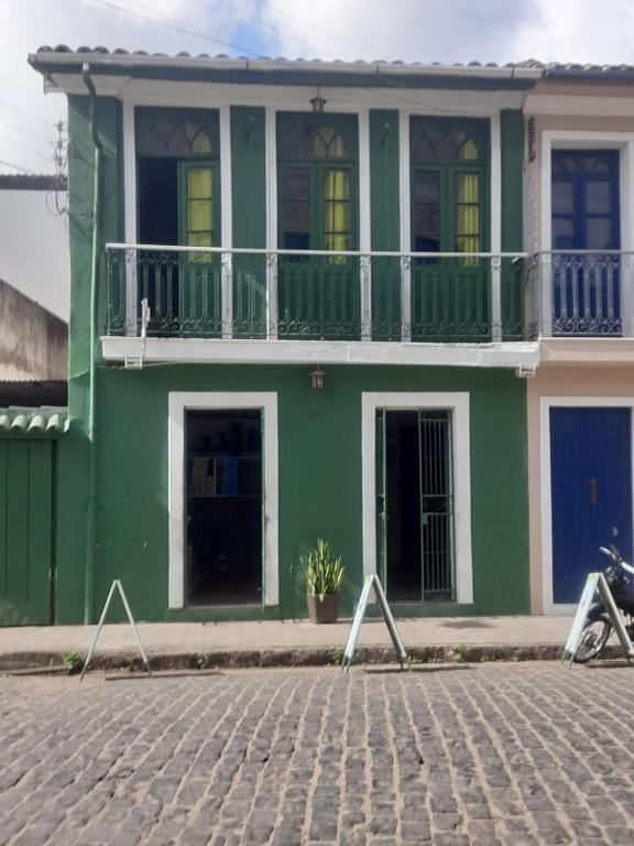 卡舒埃拉Pousada do Guerreiro的街边带阳台的绿色房屋