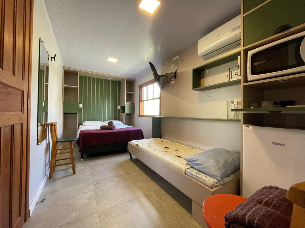 弗洛里亚诺波利斯Moçamba LODGE Contêiner的小房间设有一张床和一间小卧室
