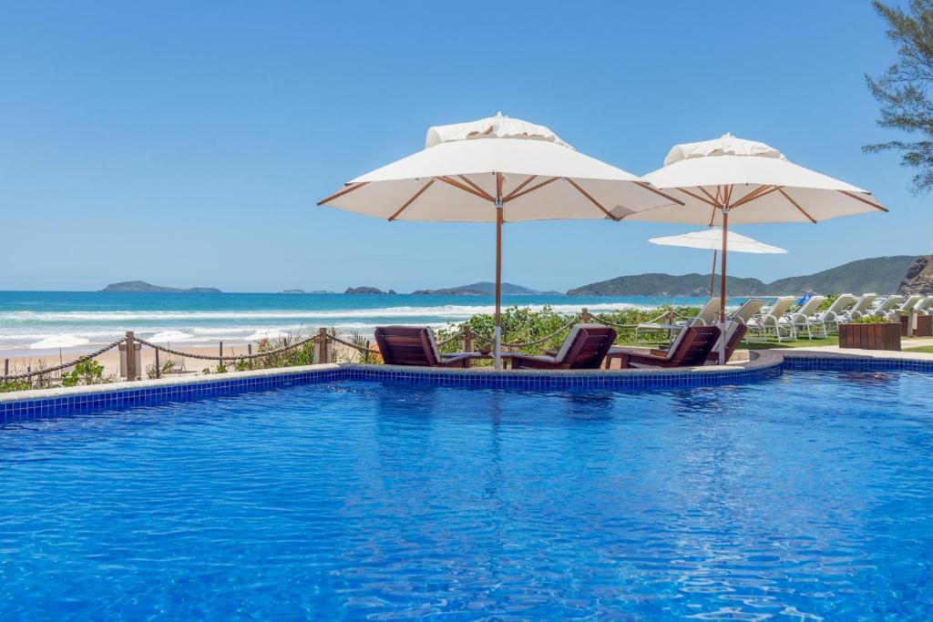 布希奥斯雷莱波利酒店 的一个带椅子和遮阳伞的游泳池和海滩