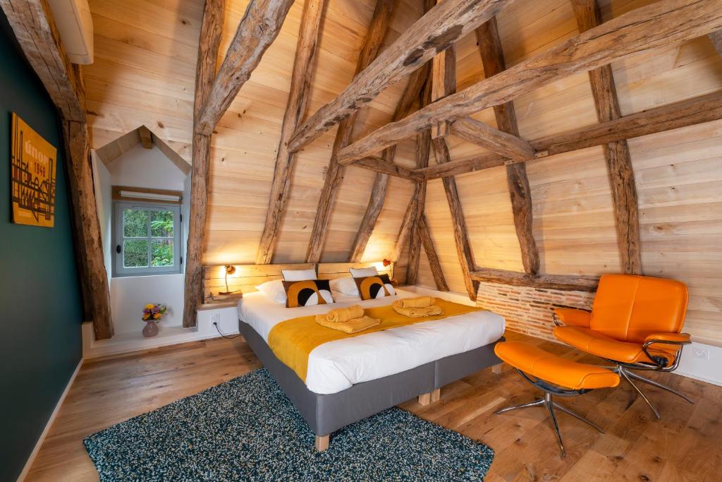圣锡尔克－拉波皮La maison de Ganil的卧室配有一张床铺,位于带木墙的房间内