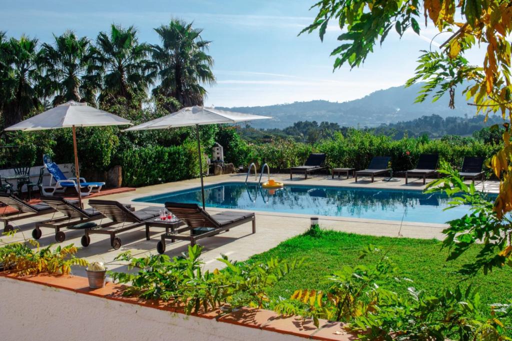 辛特拉Quinta Verde Sintra - Casa de Campo的一个带躺椅和遮阳伞的游泳池