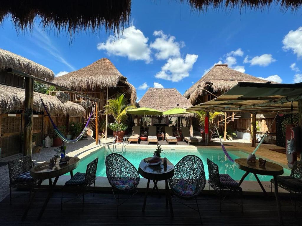 科巴Hotel Jungla y Estrellas的度假村的游泳池配有椅子和秋千