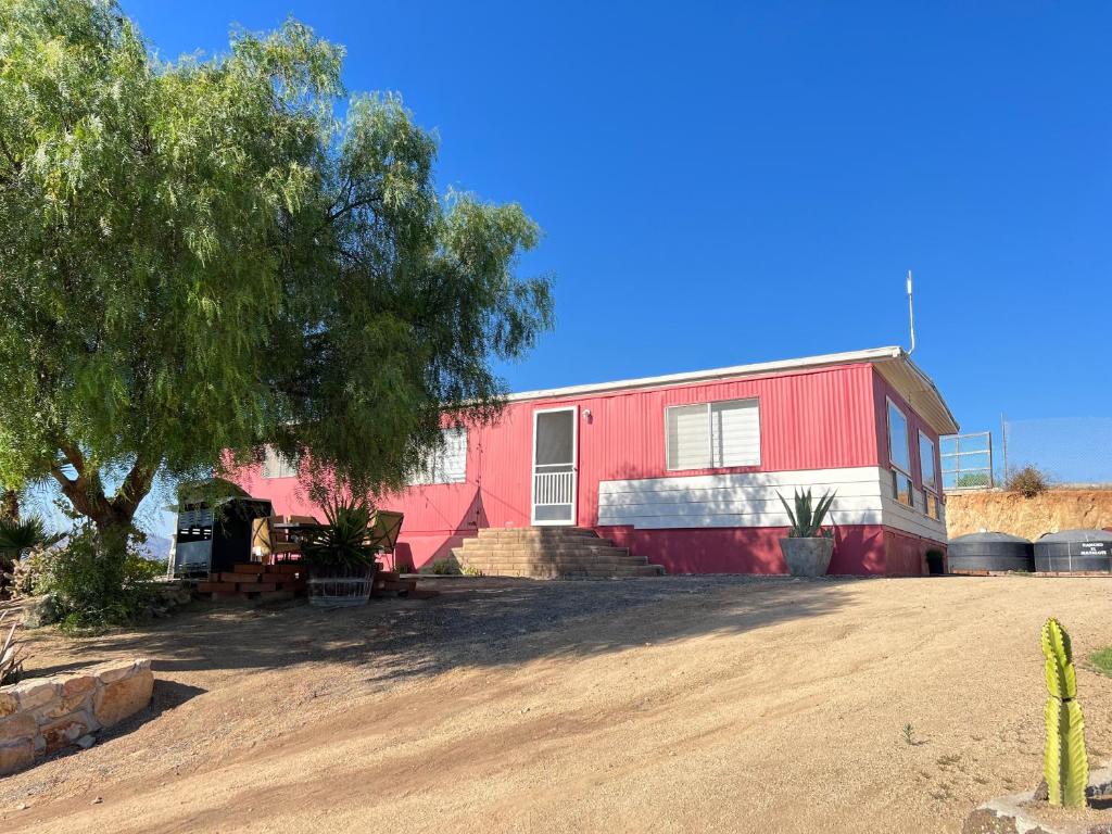 瓜达鲁佩镇Rancho Matalote en Valle de Guadalupe的前面有一棵树的红色房子