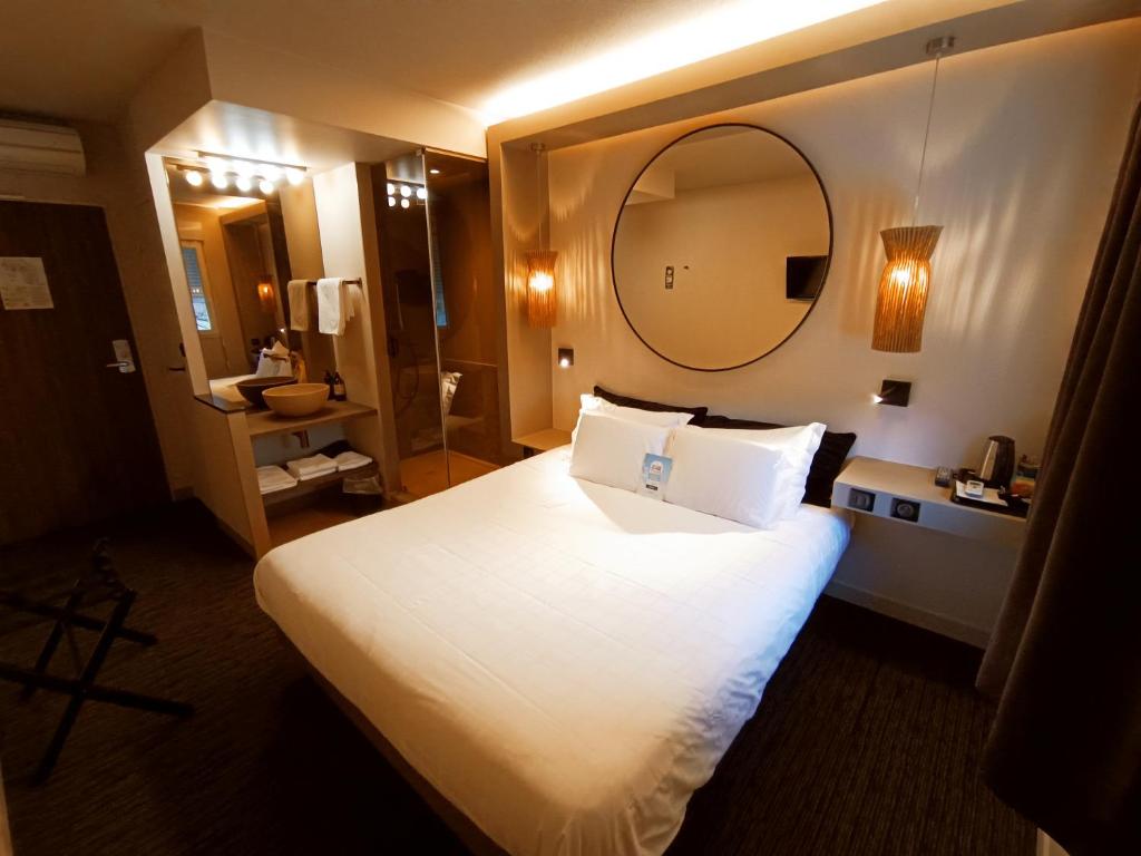布里夫拉盖亚尔德基利亚德西布里夫酒店的配有一张大床和镜子的酒店客房