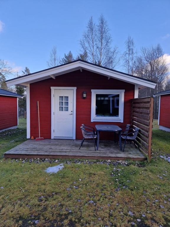 延雪平Lovsjöbadens Camping的红色的房子,甲板上配有桌椅