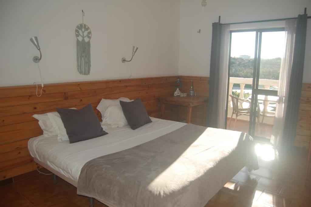 阿尔热祖尔CASA DA HORTA的一间卧室设有一张床和一个滑动玻璃门