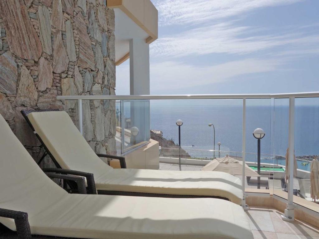阿马多雷斯阿马多雷斯韦斯特公寓式酒店的阳台配有椅子,享有海景。