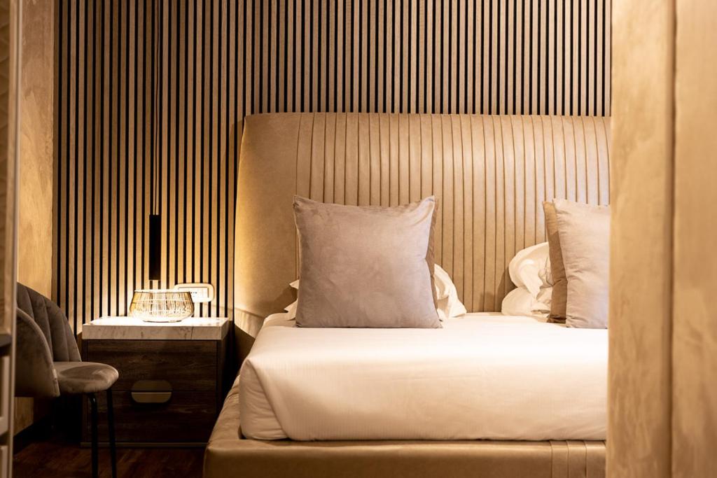 罗马西班牙皇家套房酒店的一间卧室配有一张带床头板和桌子的床