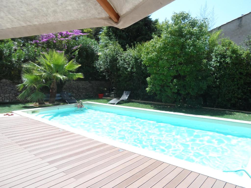 土伦Haut de villa Toulon Mourillon的一个带遮阳伞的庭院内的游泳池