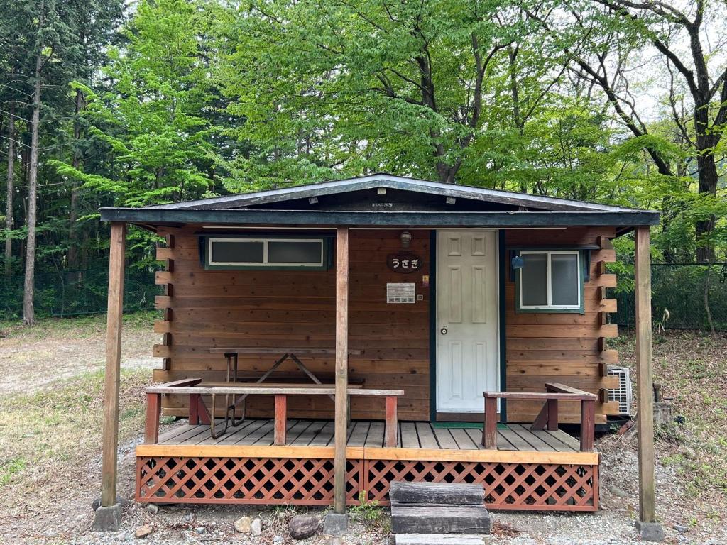 那须盐原市Nasu Takahara Auto Campsite - Vacation STAY 42066v的小木屋设有桌子和门廊
