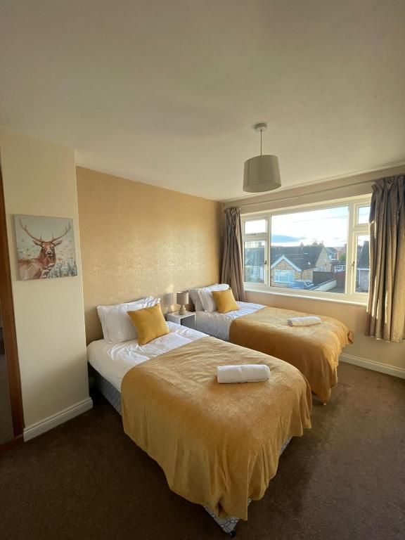 莱斯特Spacious 4-bed House in Leicester的酒店客房设有两张床和窗户。
