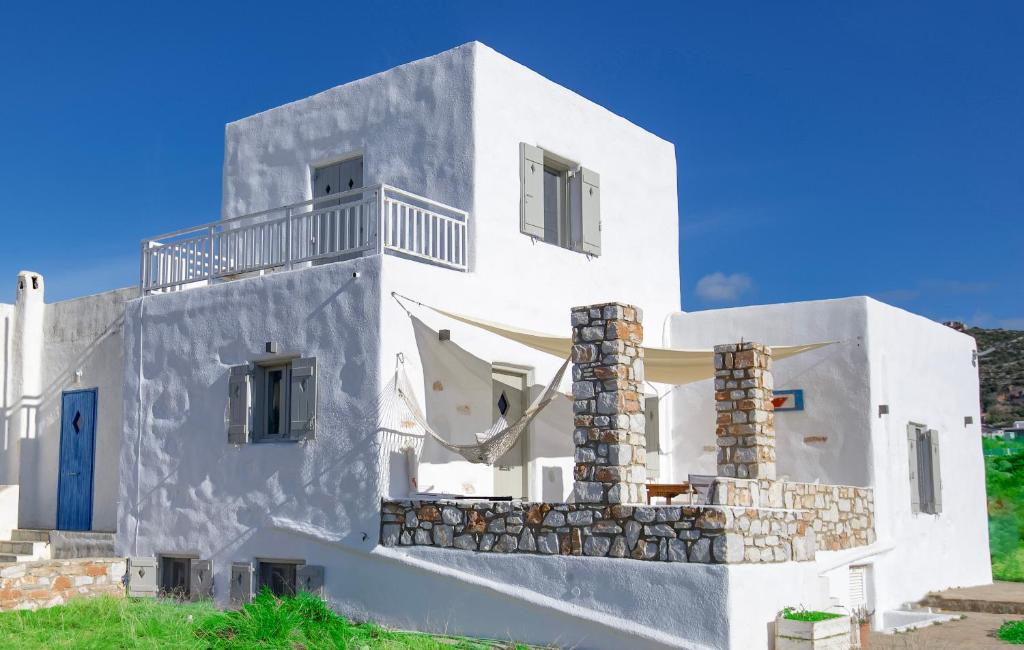 阿吉亚艾里尼帕罗Empiria House - Agia Irini - Paros的白色的房子,有蓝色的门