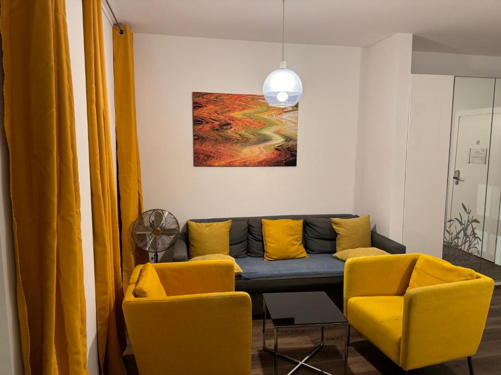 弗罗茨瓦夫GREENY的客厅配有沙发和2把黄色椅子