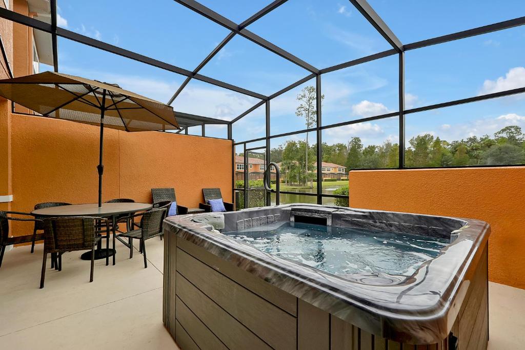 奥兰多Regal Oaks Resort Vacation Townhomes by IDILIQ的大楼内的大型热水浴池,配有桌椅
