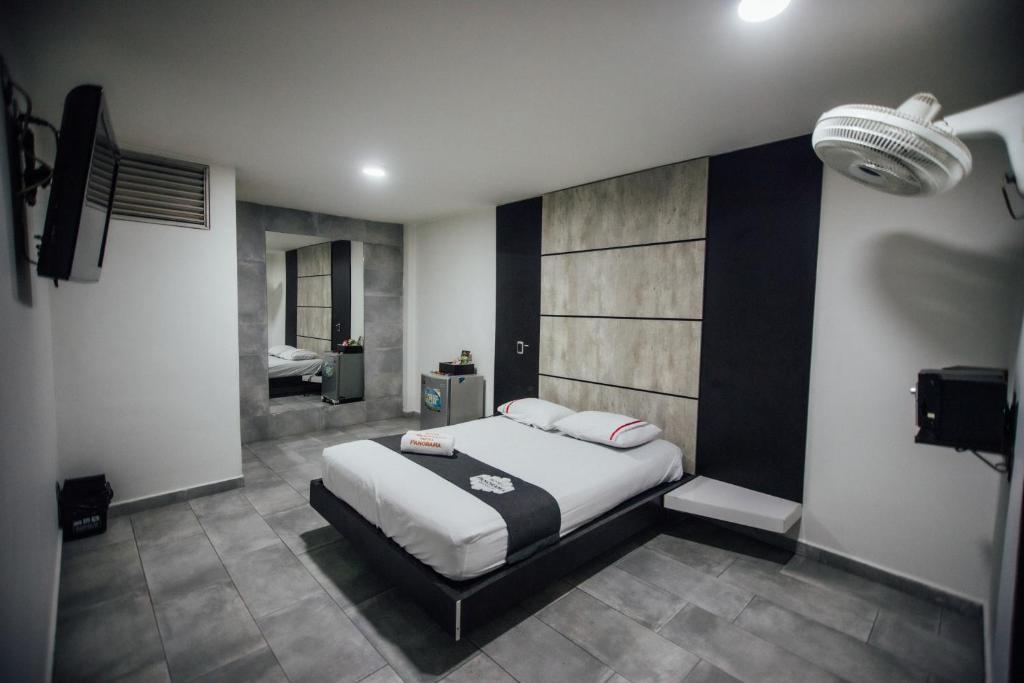 麦德林Hotel Panorama Medellín的一间带大床的卧室和一间浴室